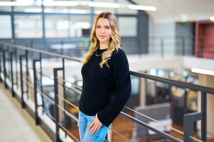 Lara Neher lehnt sich an ein Gelände und schaut in die Kamera