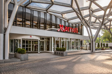 Eingang eines Marriott-Hotels mit Glasdach und moderner Architektur.