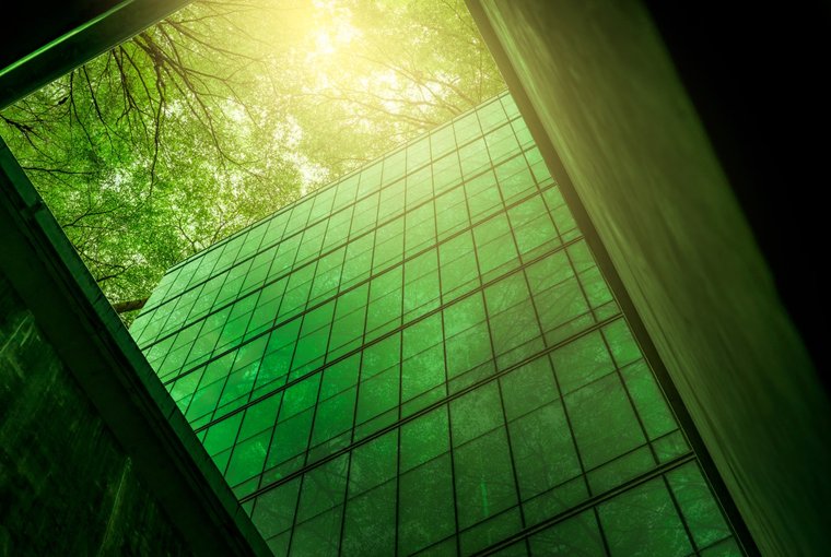 © www.istock.com/Fahroni Glasfront eines Bürogebäudes mit grüner Umgebung