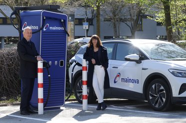 Zwei Personen an einer Ladesäule für Elektroautos