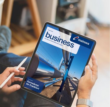 Tablet mit business Magazin wird von einem Mann im Sitzen festgehalten und das Bein ist überschlagen