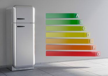 Ein Kühl-Gefriergerät und daneben die Skala der Energieeffizienzklassen von A bis G sowie grün bis rot