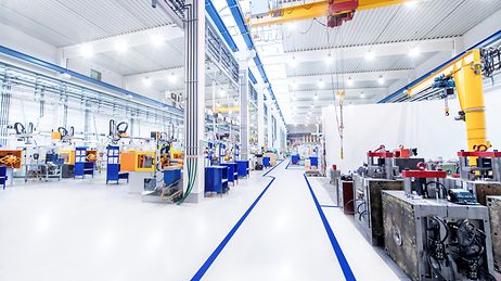 Hell beleuchtete Produktionshalle mit modernen Maschinen