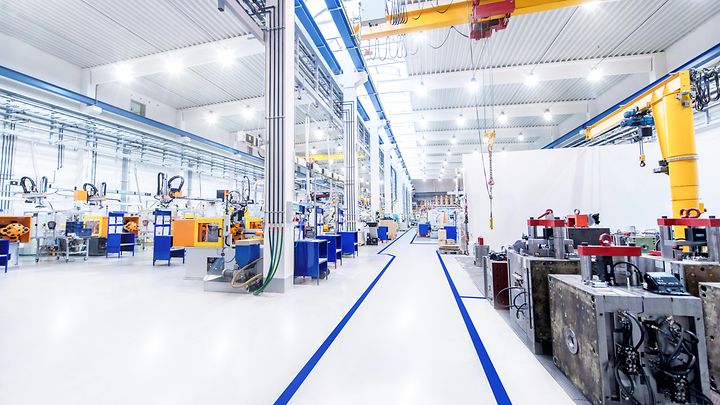 Hell beleuchtete Produktionshalle mit modernen Maschinen