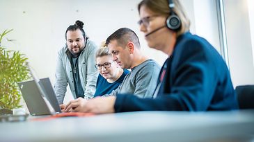 Gruppe Menschen schaut auf ein Notebook