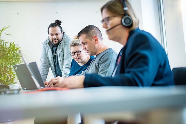 Gruppe Menschen schaut auf ein Notebook