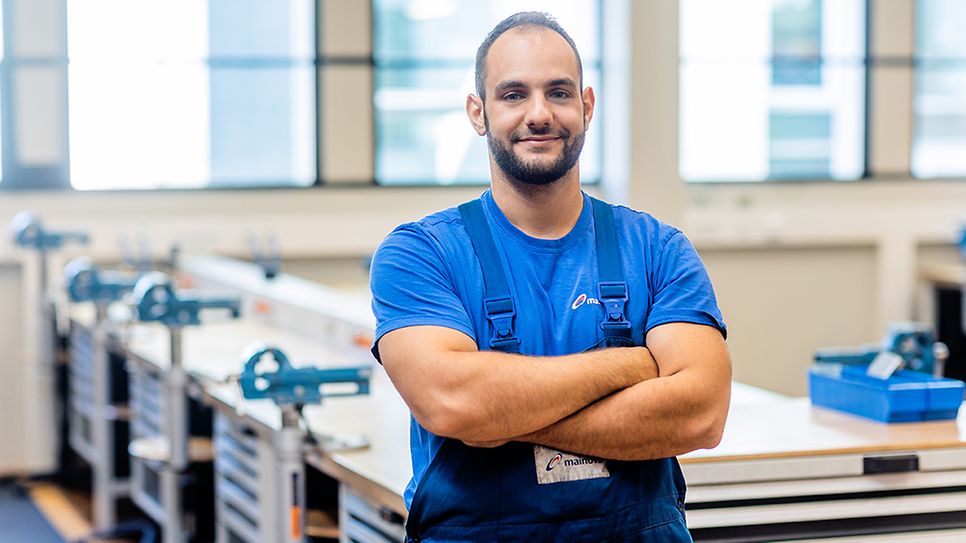 Herr Ove Schneider steht vor einer Werkbank im Ausbildungszentrum