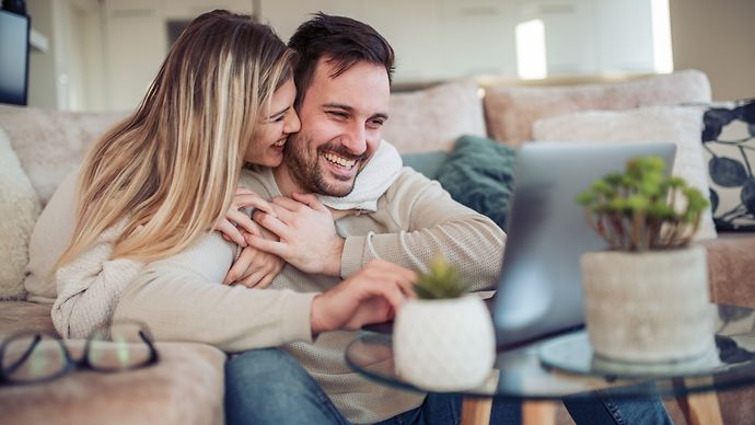 Junges Oärchen sitzt auf dem Sofa vor dem Laptop.