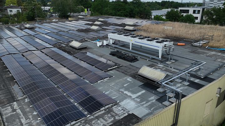 Eine große Anzahl von Solarpaneelen, die auf einem Flachdach installiert sind.