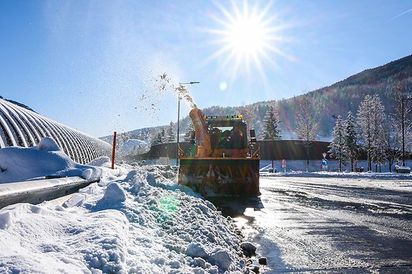 Eine verschneite Straße wird von einem Schneerpflug geräumt