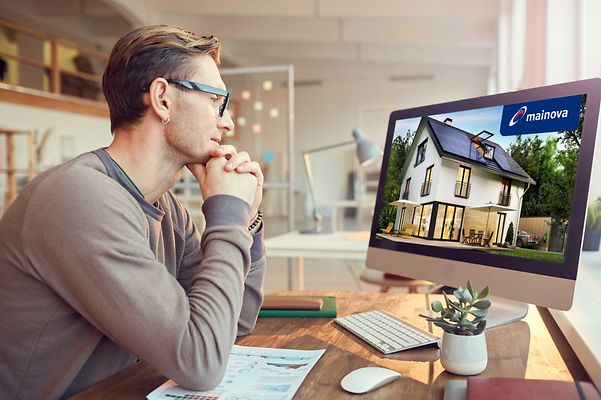 Ein Mann sitzt vor seinem Computer und nimmt an einem Online-Seminar teil.