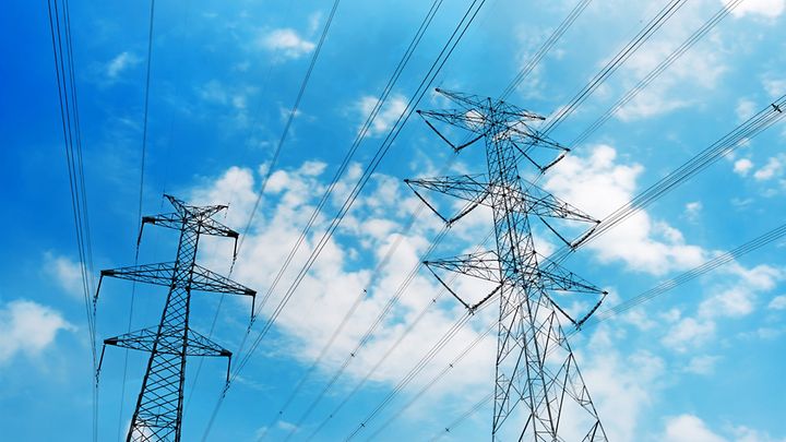 Zwei Strommasten vor blauem Himmel