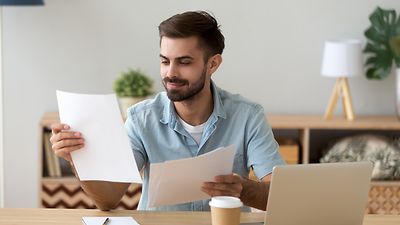 Student prüft seine ausgedruckten Bewerbungsunterlagen