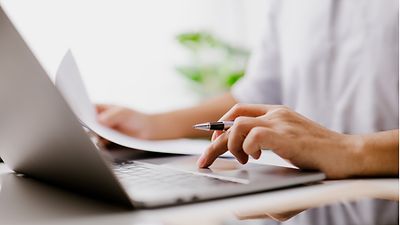 Frauenhand die ein Notebook bedient am Touchpad