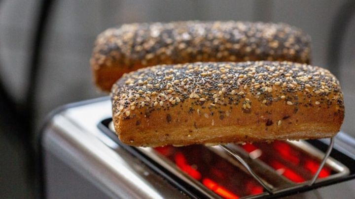 Zwei Körnerbrötchen liegen auf einem Toaster.