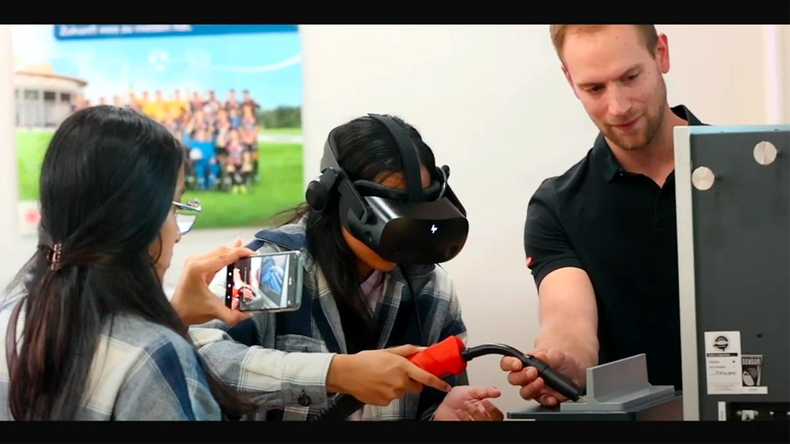 © Mainova/DennisMöbus Zwei Schülerinnen testen eine VR Brille mit einen Ausbilder