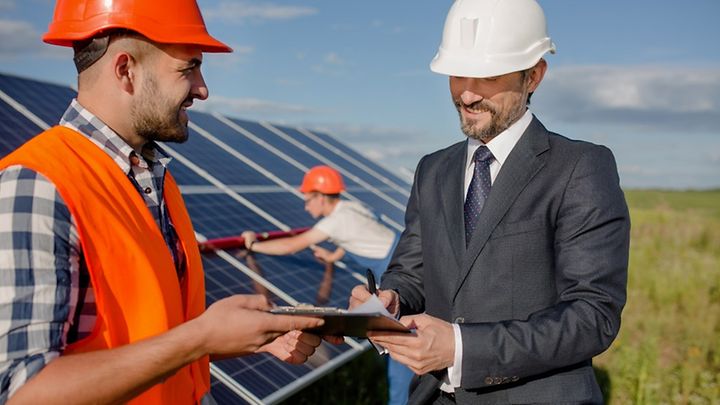 Projektleiter und Geschäftspartner vor PV-Anlage