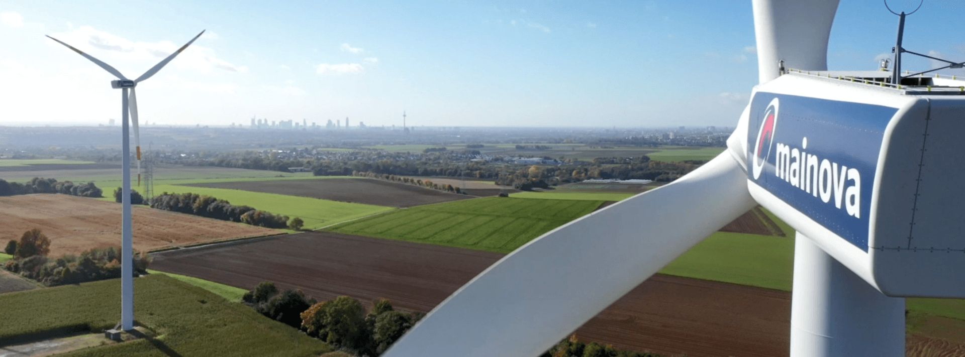 Zwei Windräder, das vordere zeigt Mainova-Logo