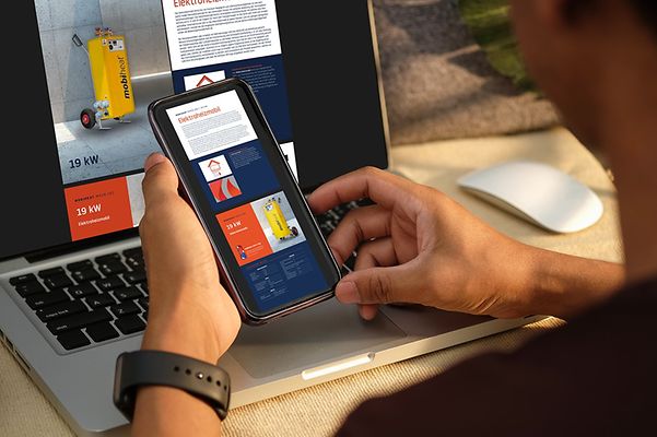Zwei Hände halten ein Mobiltelefon, auf dem Katalogbilder zu sehen sind