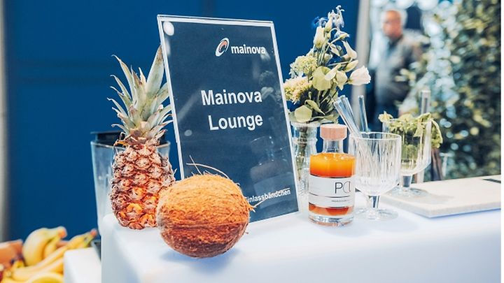Lounge-Tisch mit Früchten, Blumen und Getränken, Schild "Mainova Lounge"