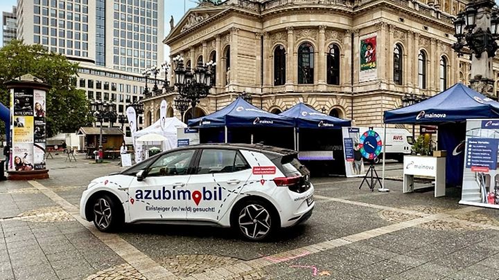 "Azubimobil"vor einem Platz mit Ständen und einem historischen Gebäude der "Alten Oper"