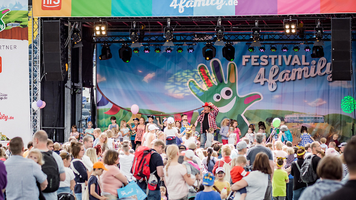 Bühne mit Plakat vom Festival4Family und einer Menschenmenge davor