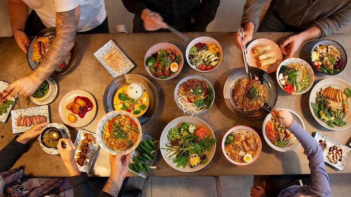 Asiatisches Essen auf Tellern auf einem Tisch von oben