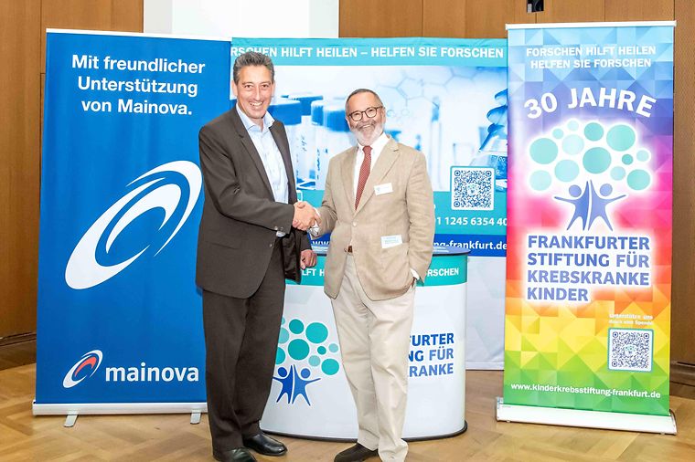 © Lisa Farkas Dr. Michael Maxelon (Mainova) schüttelt Dr. Jürgen Vogt (Frankfurter Stiftung für krebskranke Kinder) die Hand