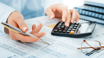 Vater, Sohn und Dackel liegen auf dem Wohnzimmerteppich und machen schriftliche Hausaufgaben