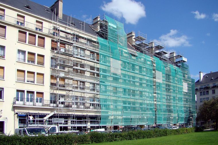 © www.adobestock.com - Catherine Clavery Mehrfamilienhaus mit Gerüst an der Fassade