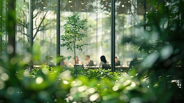 Menschen in einem Meeting und im Vordergrund Pflanzen