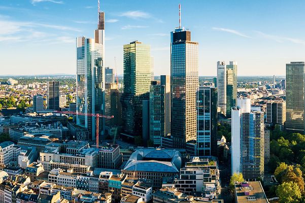 Die Skyline von Frankfurt am Main mit modernen Hochhäusern und blauem Himmel.