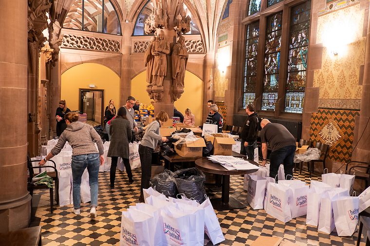 Ratskeller des Frankfurter Römers, viele Personen packen Geschenktüten ein