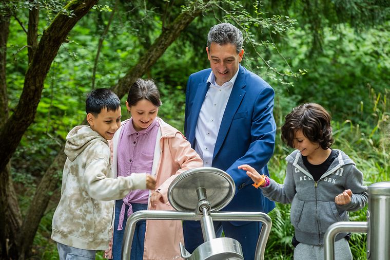 © Heiko Rhode Drei Kinder und ein Mann spielen an Geräten in einem Wasserpark