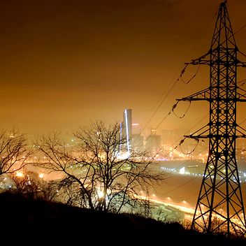 © www.istock.com - voffkatw Strommast bei Nacht im Hintergrund beleuchtete Skyline