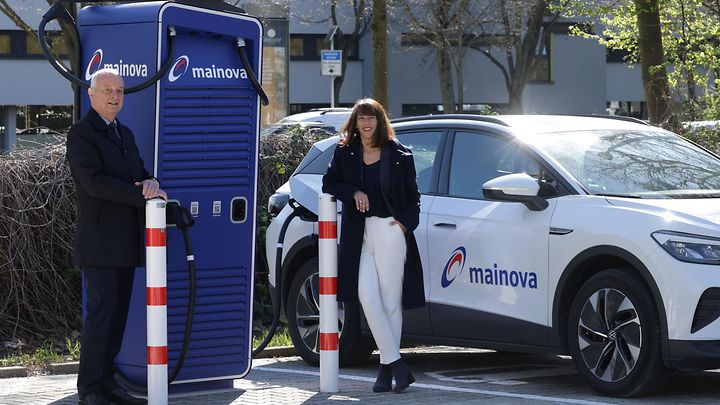 Zwei Personen an einer Ladesäule für Elektroautos