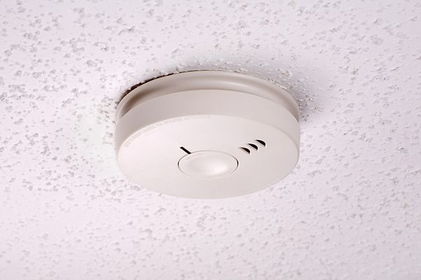 Ein weißer Rauchwarnmelder, der an der Decke befestigt ist