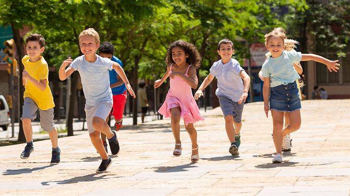Kinder rennen glücklich auf einem Weg zwischen Bäumen