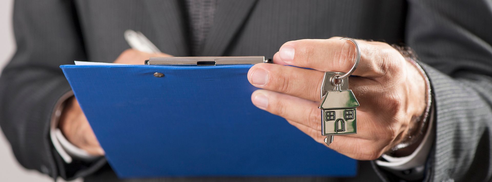 © www.istock.com - abioBalbi Eine Hand hält ein Übergabeprotokoll, die andere Hand einen Hausschlüssel