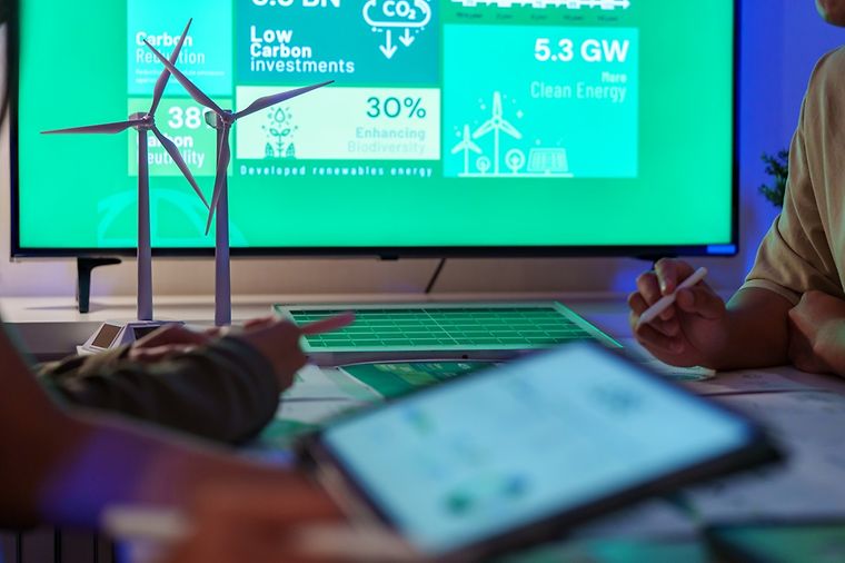© istock - Weedezign Besprechung zwischen zwei Personen. Auf Bildschirmen werden Daten zu CO2-Bilanzen gezeigt.