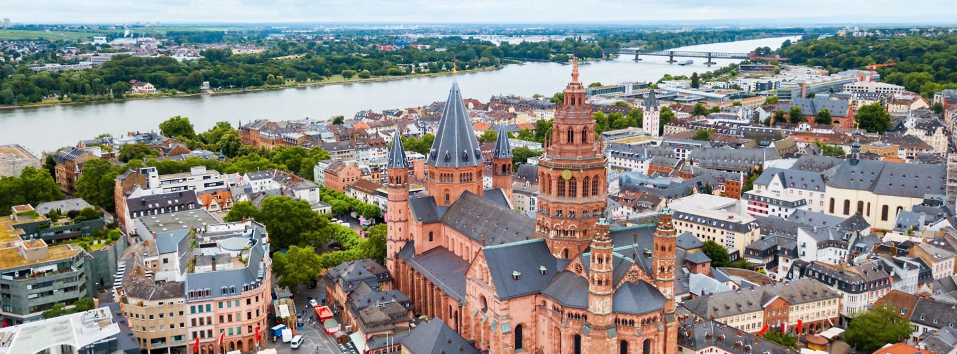 Bild aus der Vogelperspektive zeigt Mainzer Innenstadt, den Mainzer Dom und den Rhein im Hintergrund.