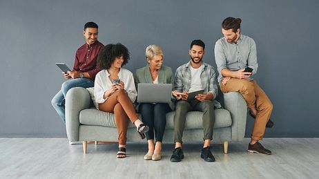Fünf Leute sitzen auf einer Couch.