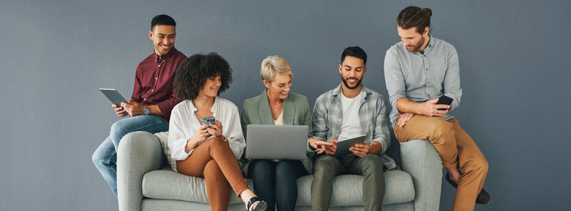Fünf Leute sitzen auf einer Couch.