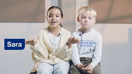 Ein kleines Mädchen und ein kleiner Junge sitzen nebeneinander