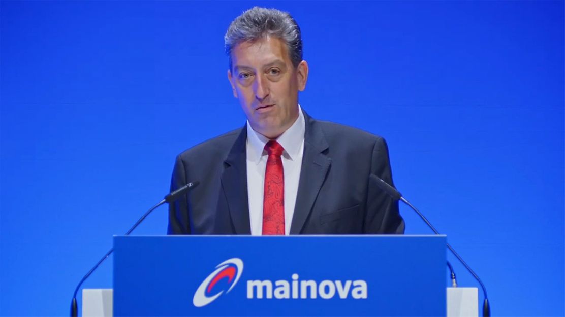 Dr. Maxelon spricht am Mainova-Rednerpult vor blauem Bühnenhintergrund.