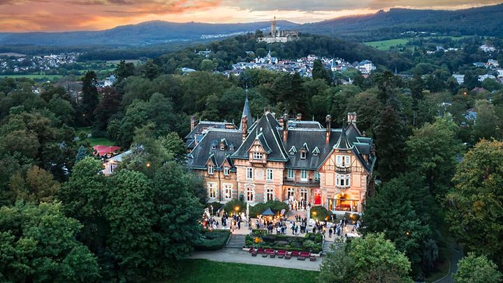 Luftaufnahme der Villa Rothschild im Parkgelände bei Abendstimmung