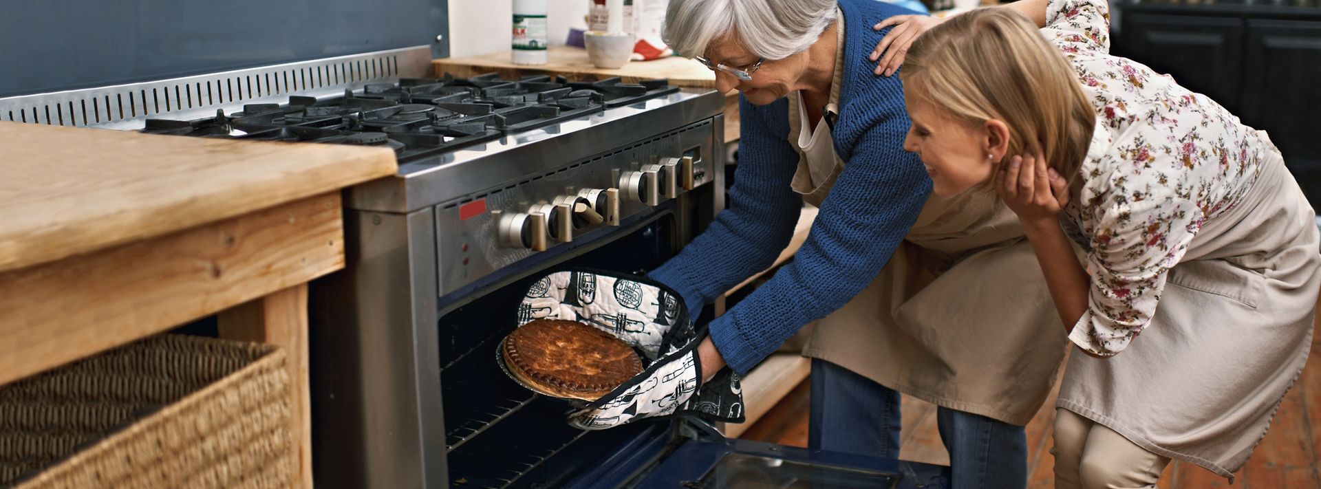 Mutter holt Kuchen aus dem Gasbackofen