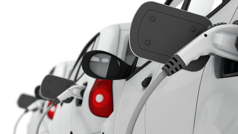 E-Autos in einer Reihe werden geladen