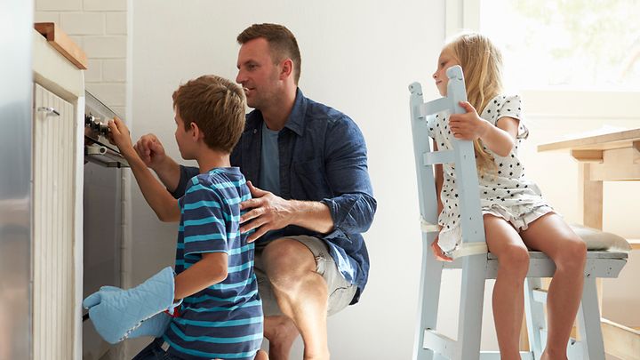 Ein Vater und seine zwei Kinder prüfen die Herdfunktion