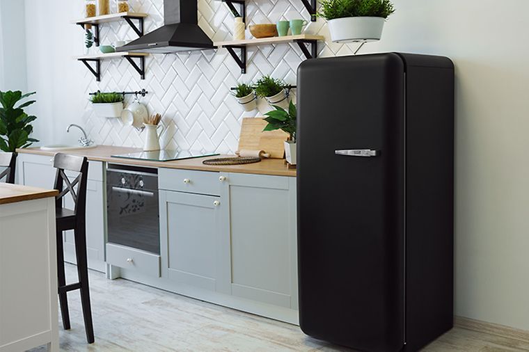 Küchenzeile mit großem schwarzem Kühlschrank rechts